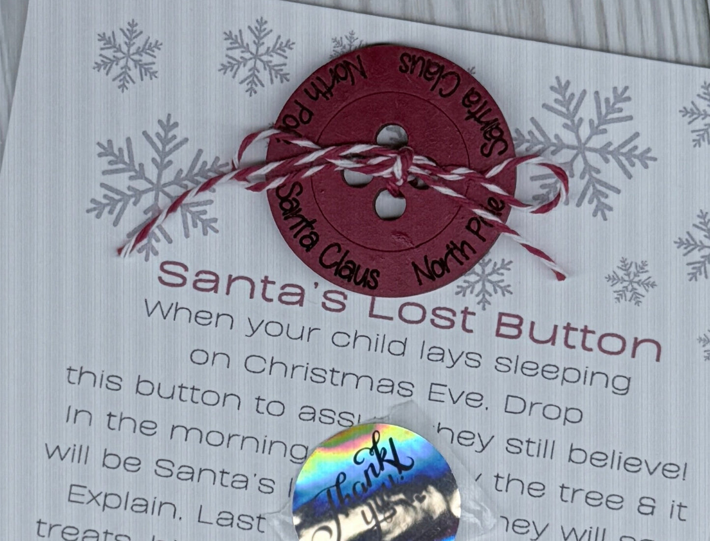 Card with a red button and text on a wooden surface