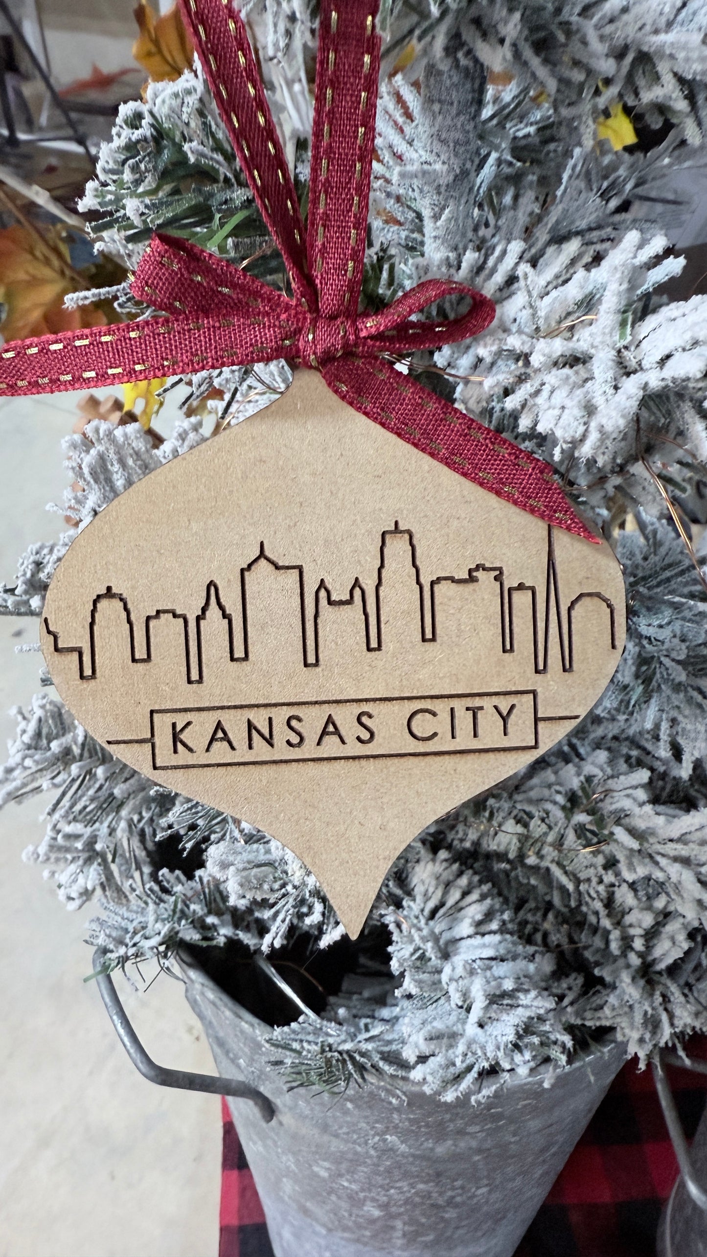 Decorative ornament with Kansas City skyline engraved design on a tree