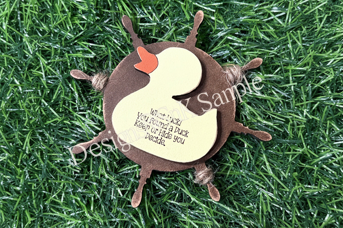 Decorative duck ornament with text on a grass background