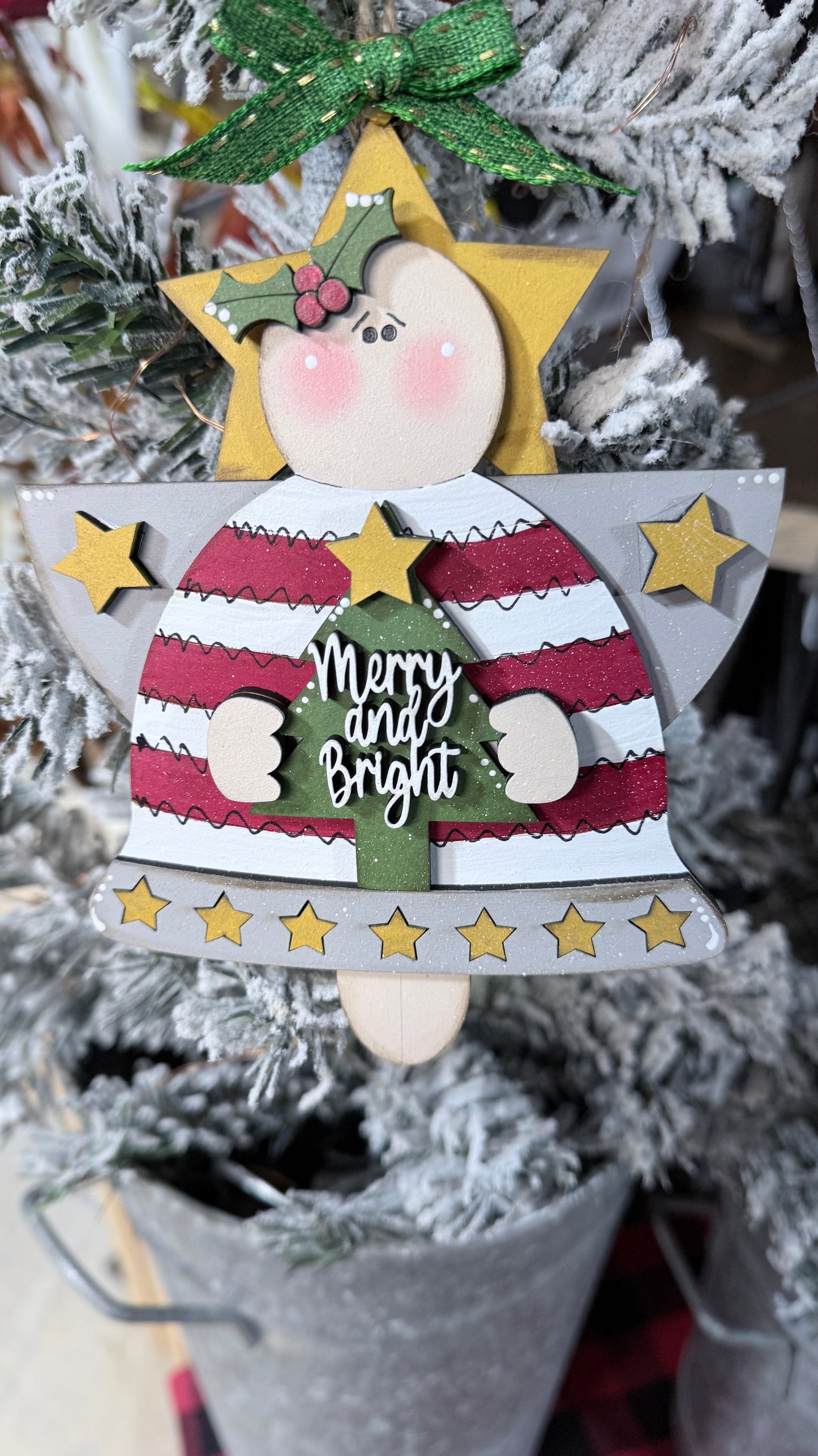 Decorative Christmas angel ornament with 'Merry and Bright' text on a tree.