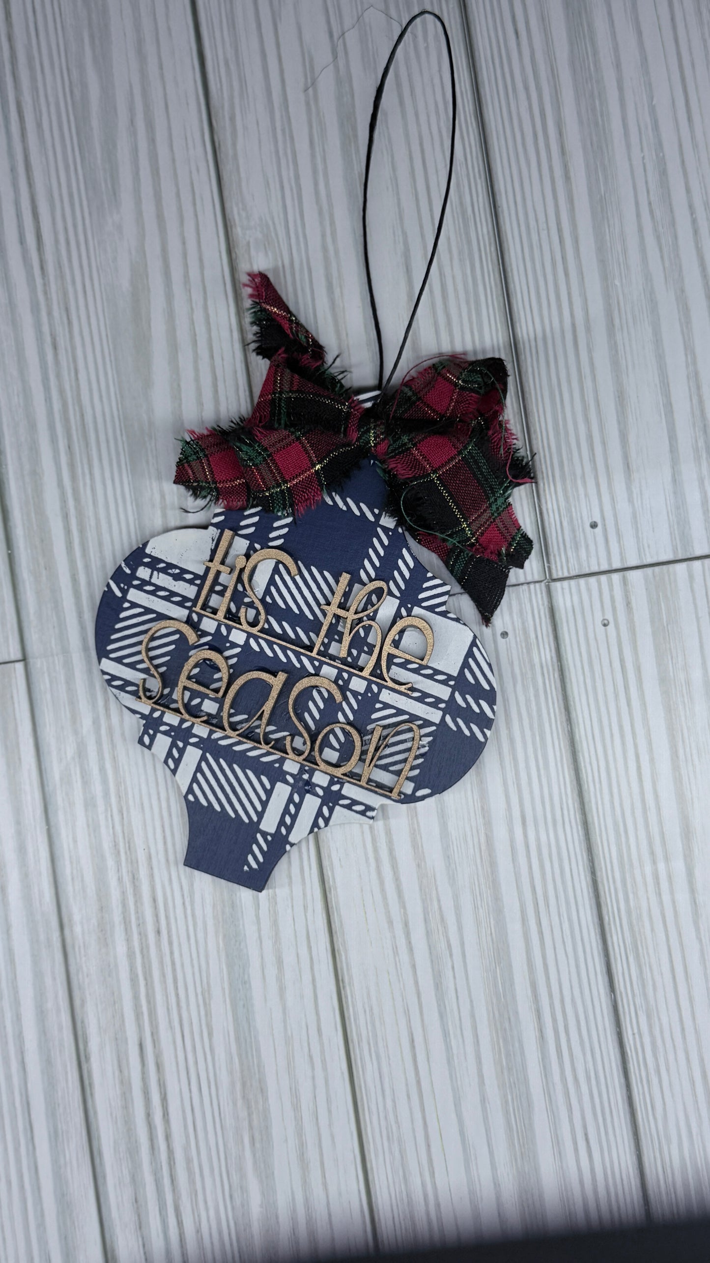Decorative ornament with plaid pattern and bow on a wooden surface