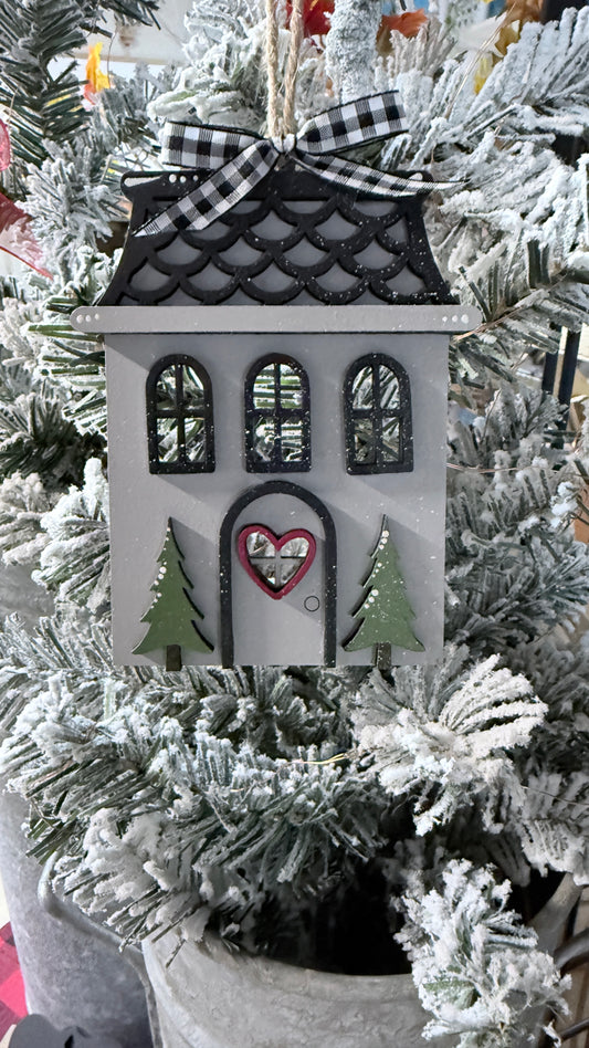 Decorative house ornament with a heart on a Christmas tree