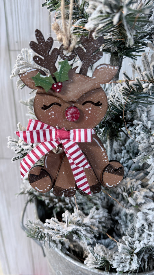 Decorative reindeer ornament with a bow on a Christmas tree.