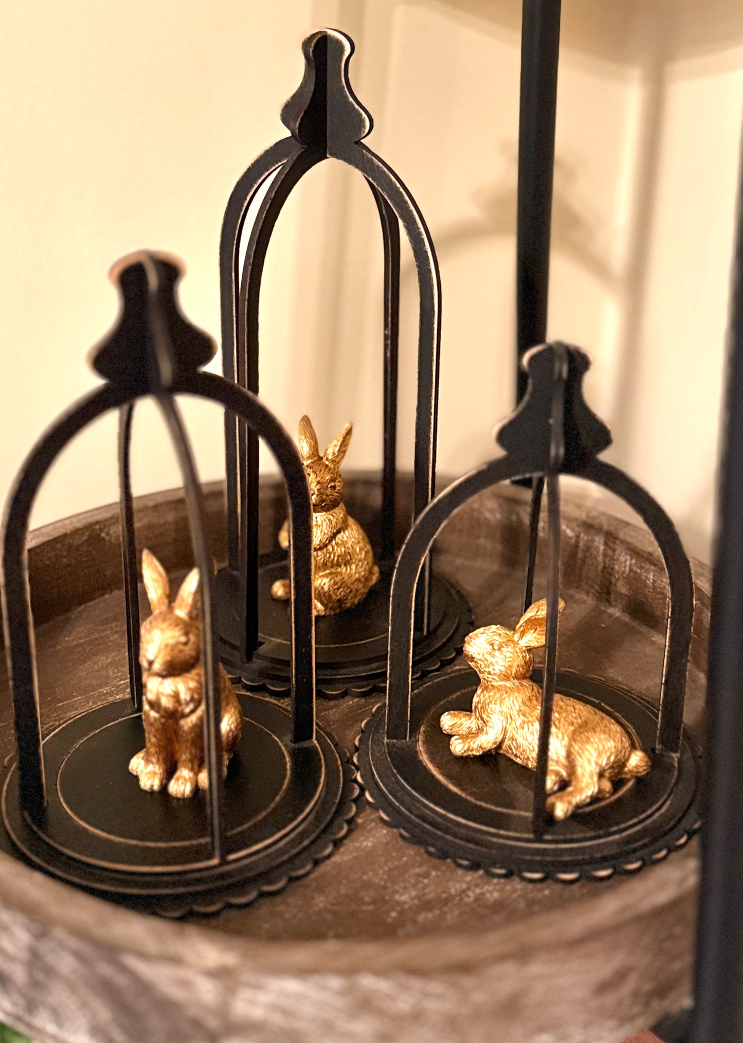 Decorative handmade cloche set of three displayed for Easter. Gold bunnies sitting inside. 