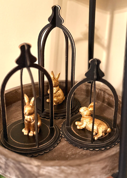 Decorative handmade cloche set of three displayed for Easter. Gold bunnies sitting inside. 