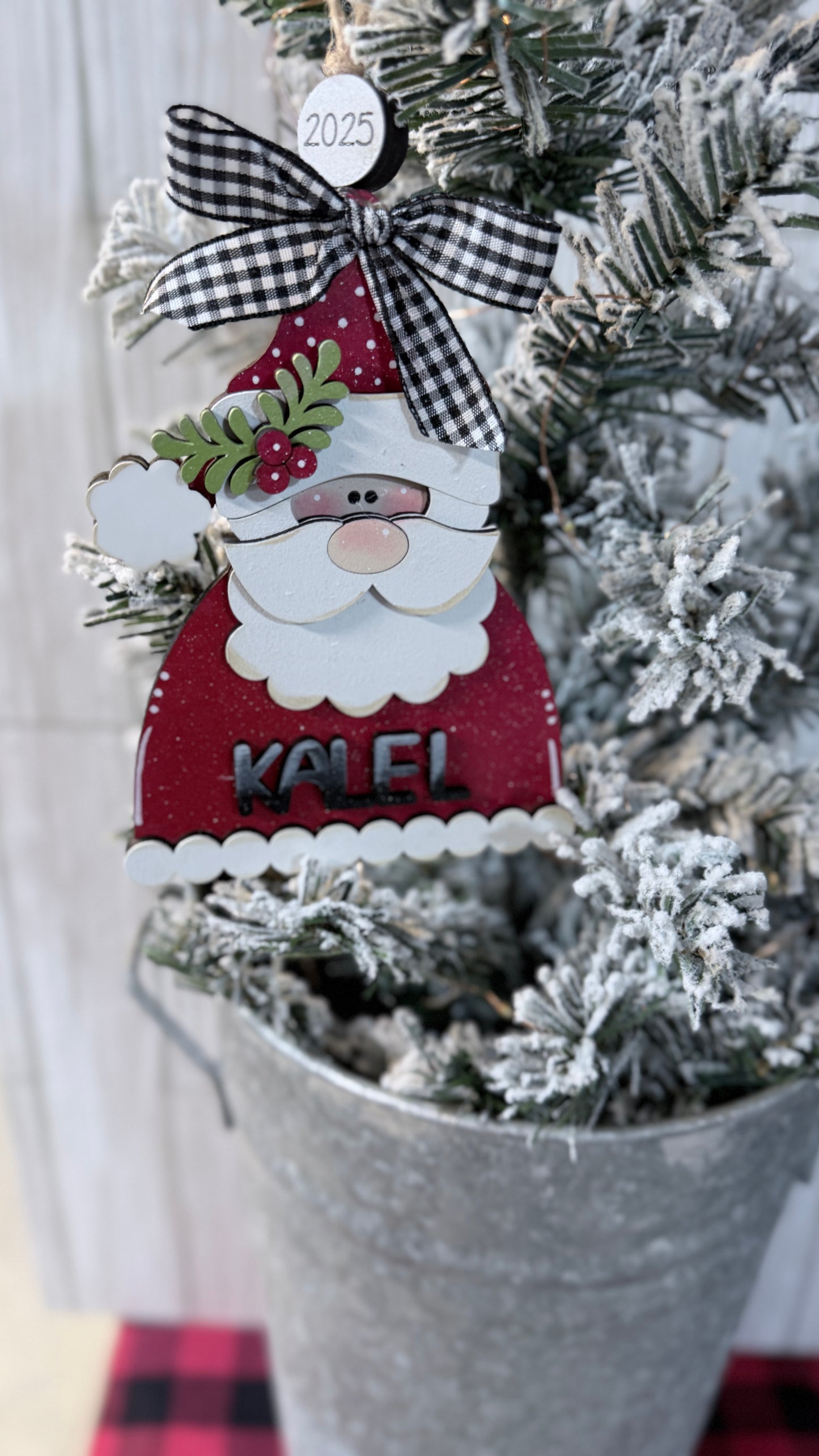 Decorative Santa Claus ornament with 'Kaiel' on a Christmas tree.