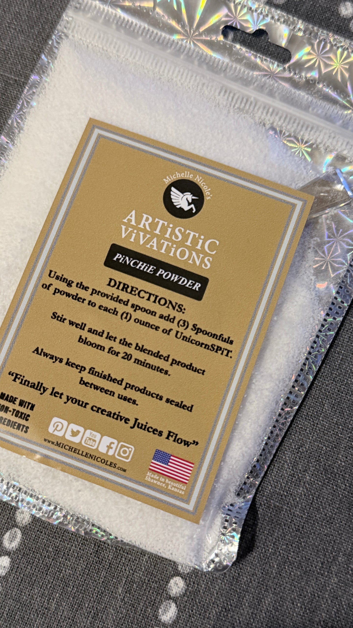 Artistic Vivations pinch powder packaging with directions label on a reflective surface.