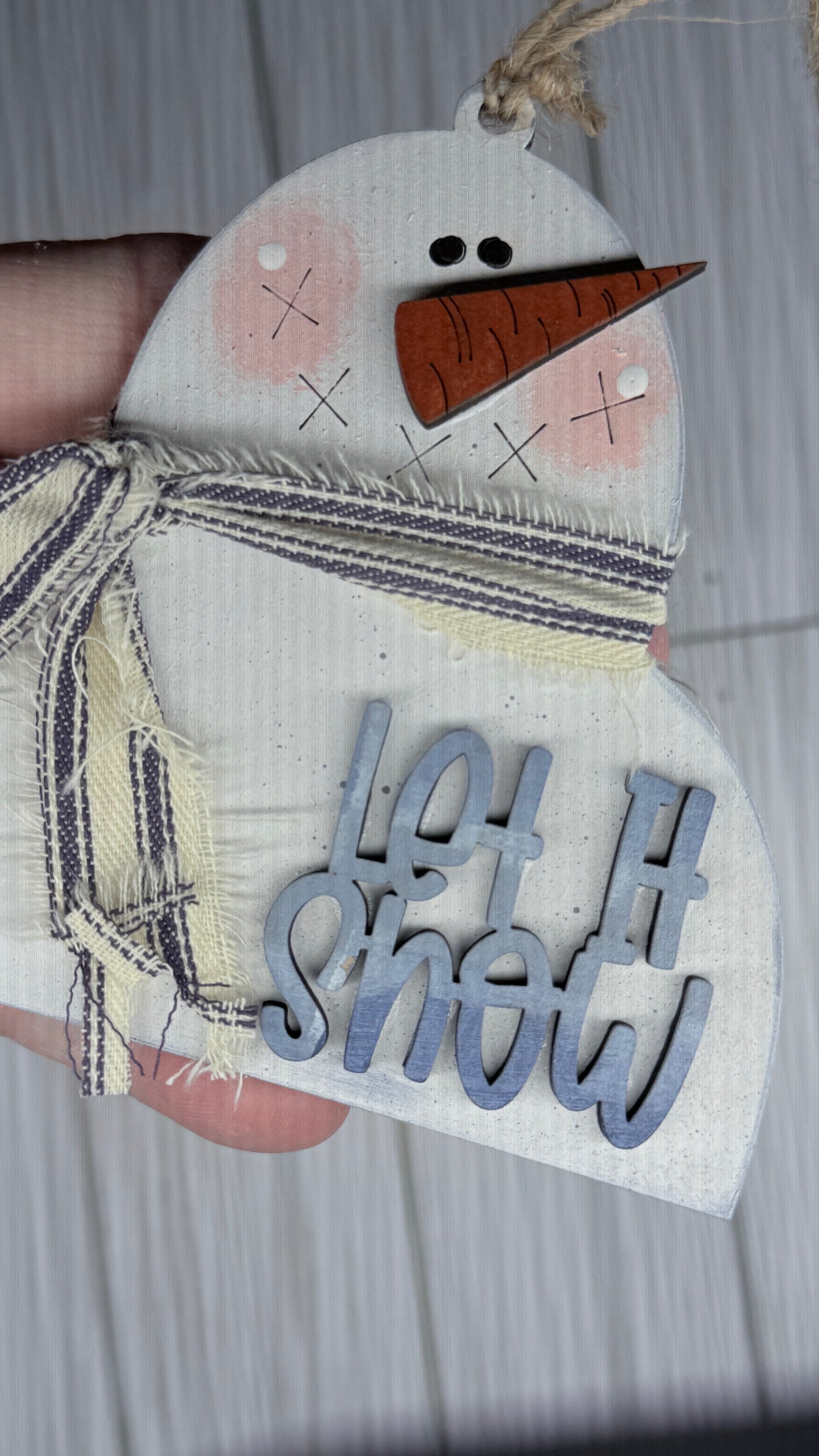 Decorative snowman ornament with 'Let It Snow' text on a white background