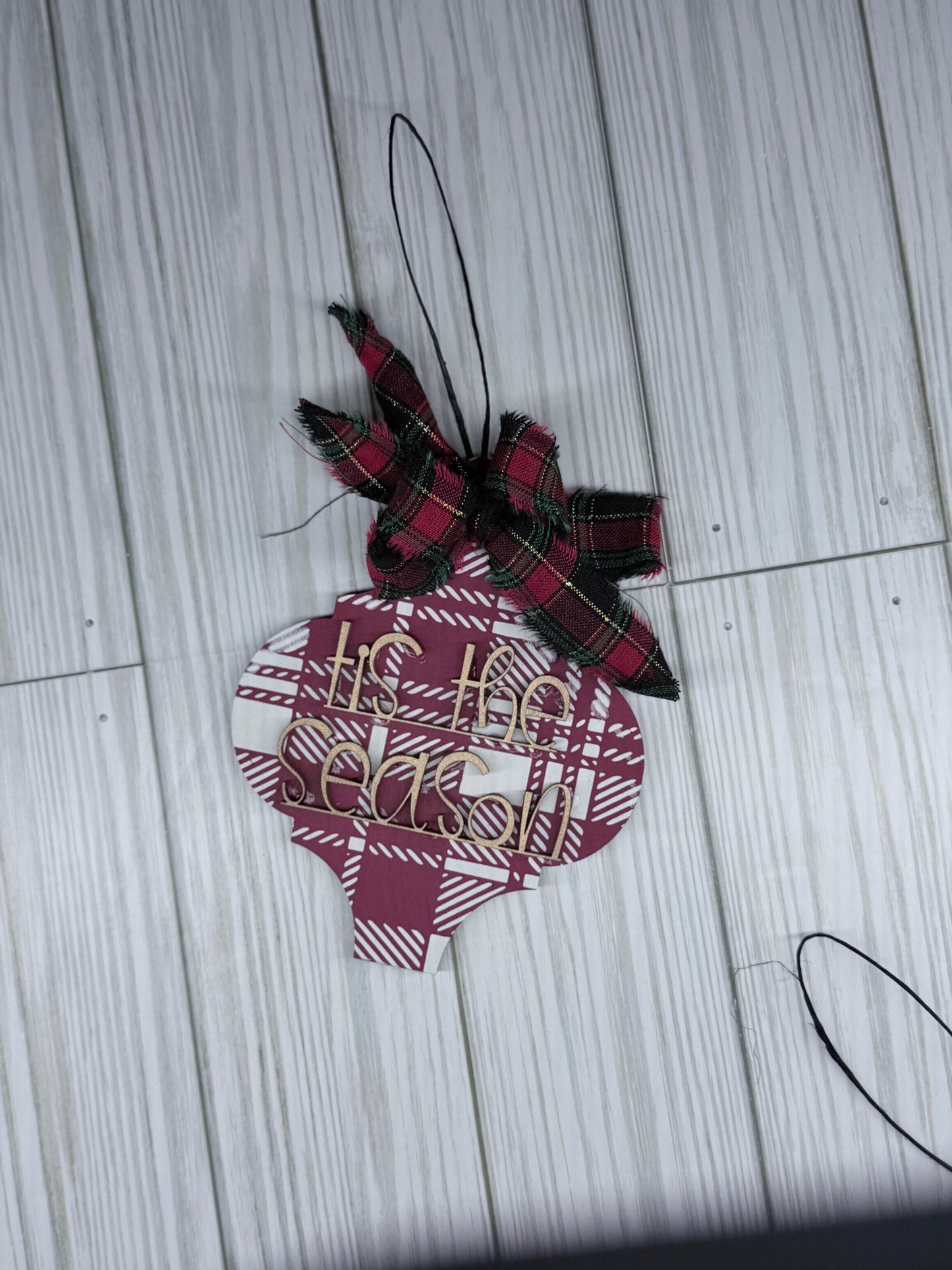 Plaid ornament with a bow on a wooden surface