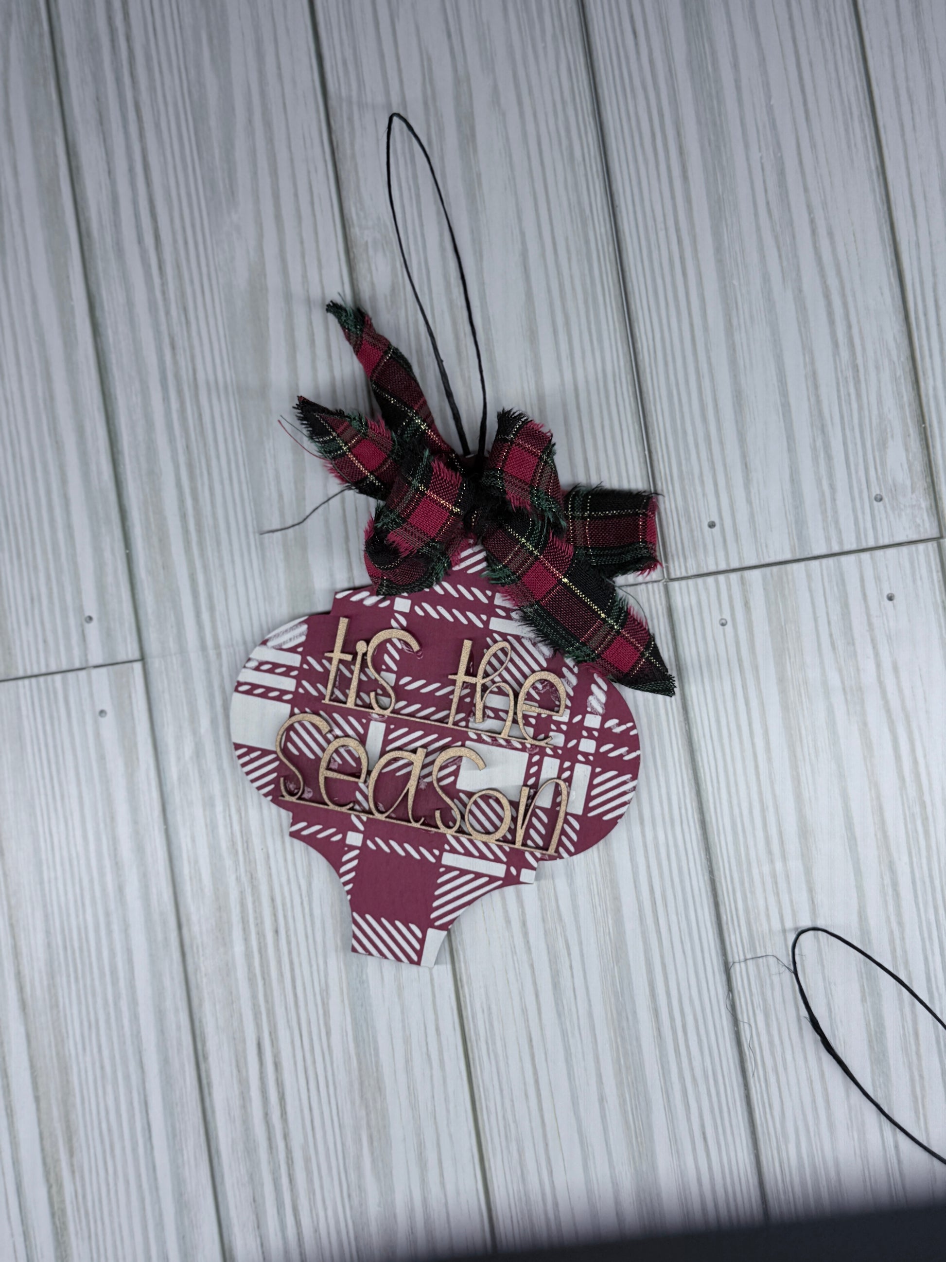 Plaid ornament with a bow on a wooden surface