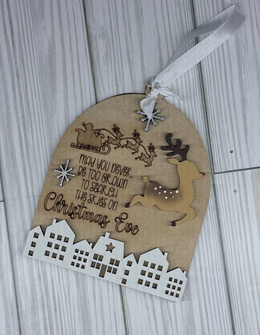 Decorative ornament of Santa flying over the homes as his reindeer lead the way.   "May you never be too grown up to search the skies on Christmas Eve" engraved.  