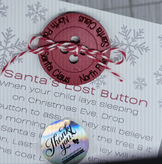 Button labeled 'Santa's Lost Button' on a card with text and tied with thread as if it popped off Santa's coat while leaving presents. 