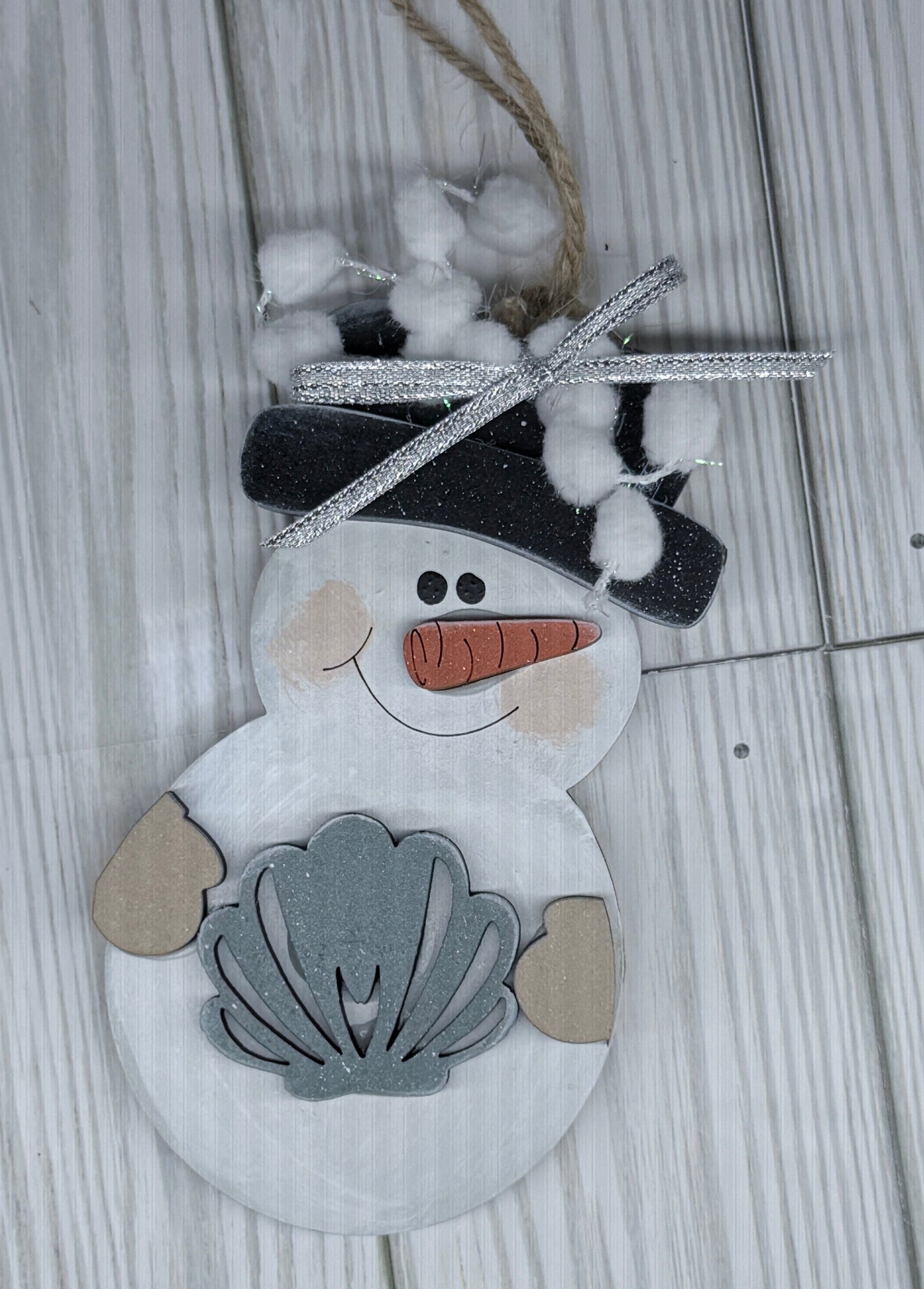 Decorative snowman ornament with shell on a wooden surface
