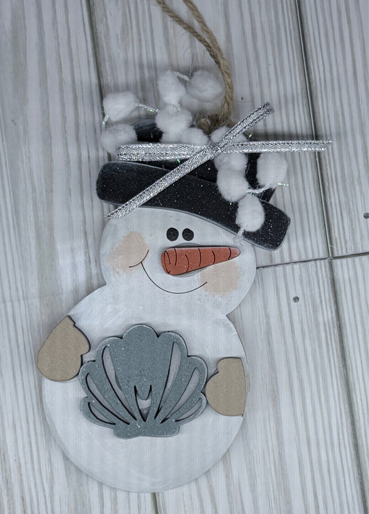 Decorative snowman ornament with shell on a wooden surface